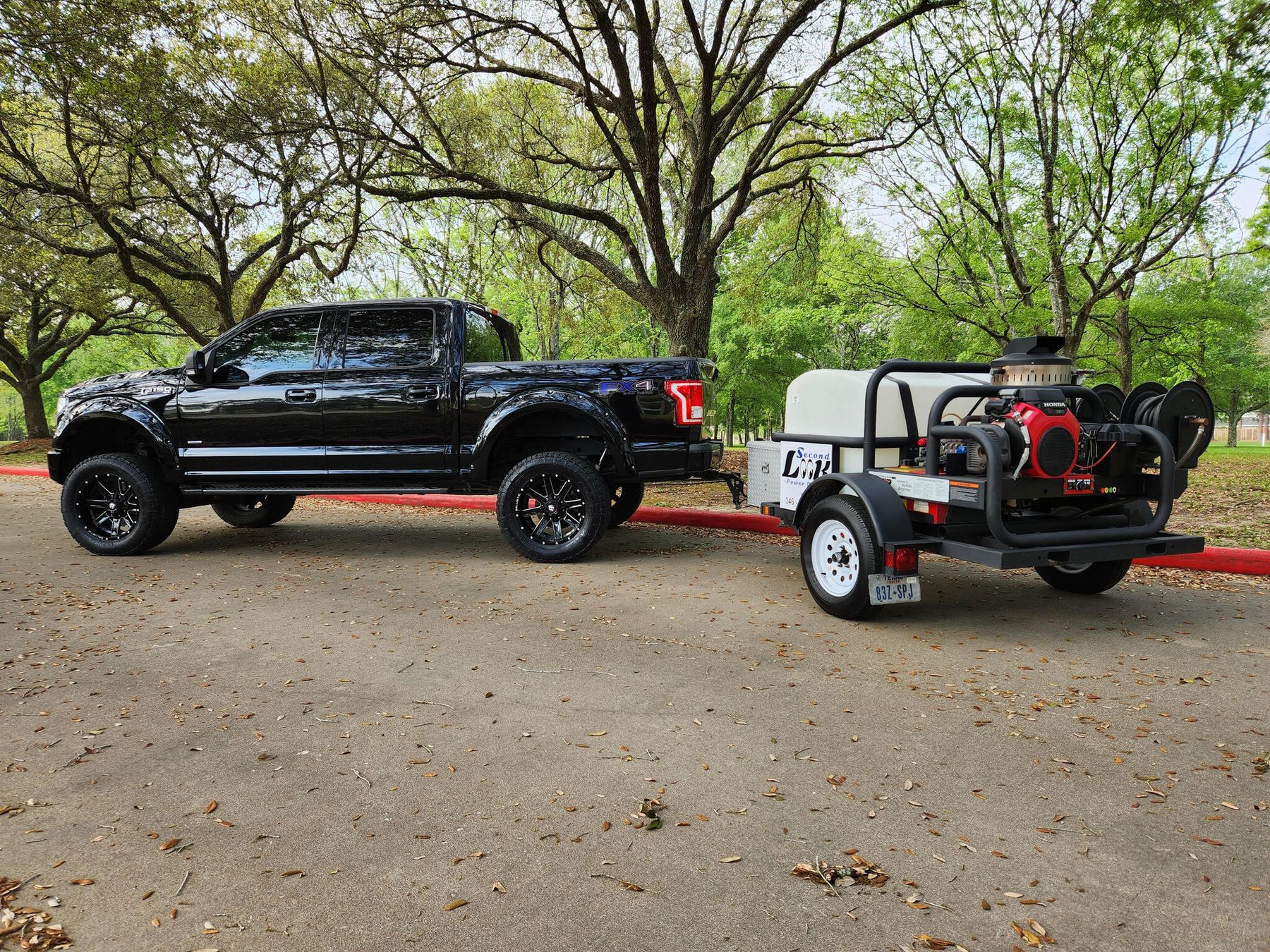 Second Look Power Wash pickup towing the company's branded pressure washing trailer
